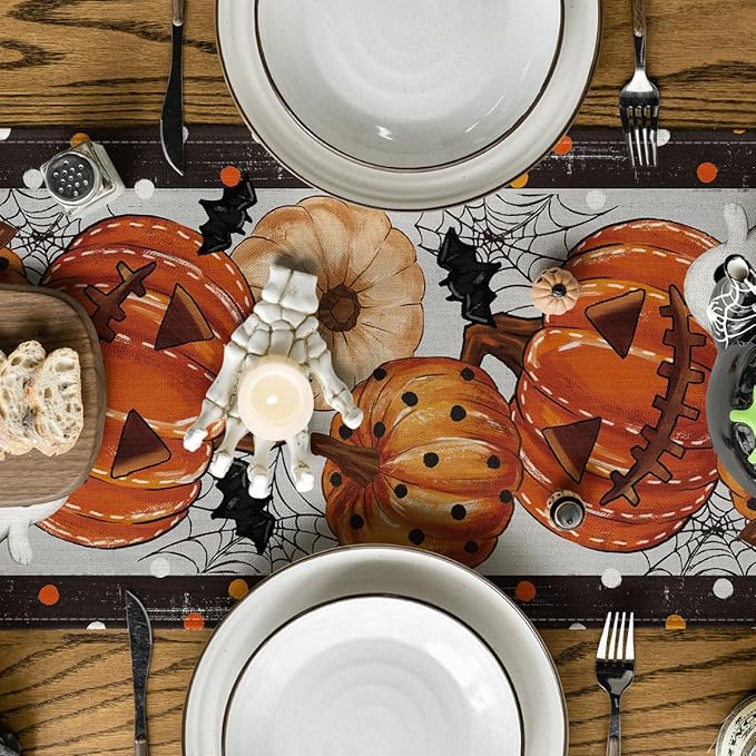 Close-up Halloween table runner: orange pumpkins, beige flower, spiderweb pattern