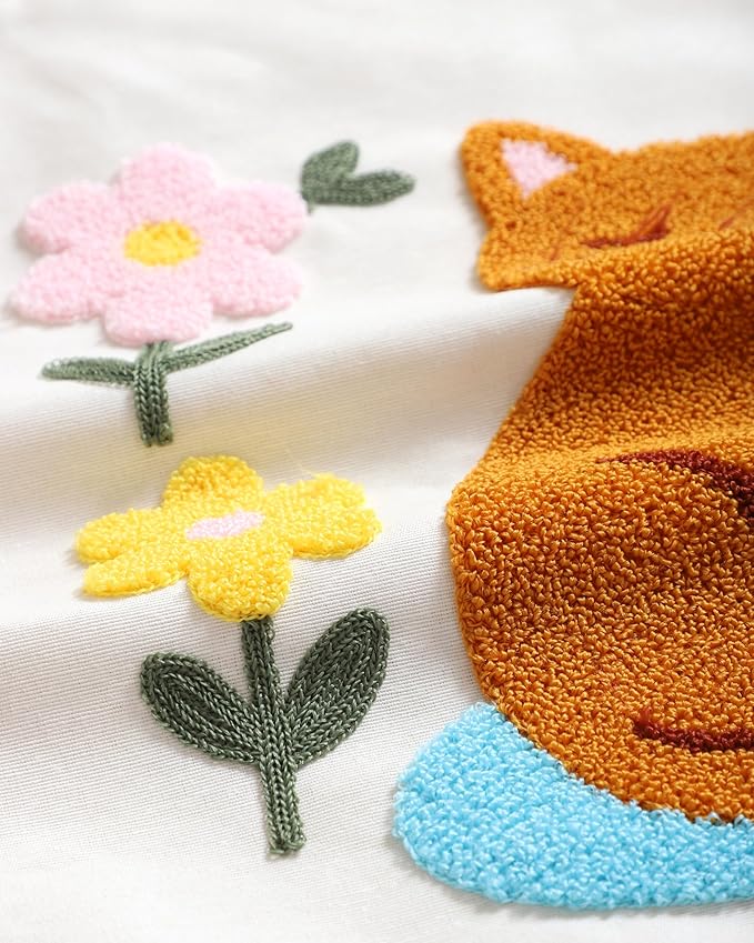 Embroidered orange cat and pastel flowers on a cream throw pillow cover
