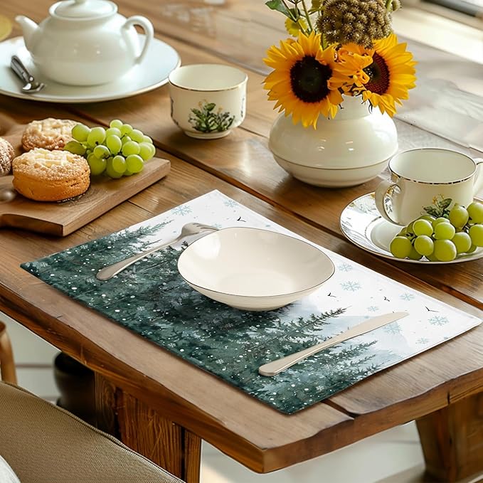 Green snowy forest placemat with pine trees and snowflakes, used on a dining table