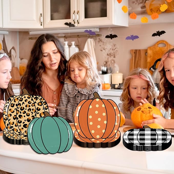 Pumpkin-shaped paper party plates in leopard, teal, orange polka, and black plaid