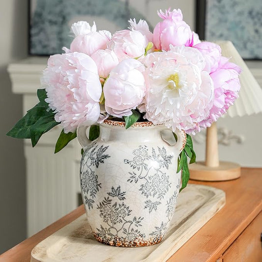Double-handled ceramic vase with blue floral pattern, holding pink peony blooms