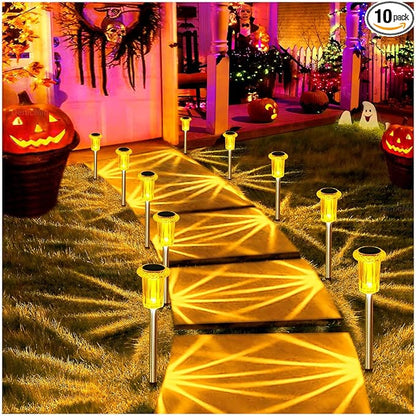 Outdoor solar stake lights with amber glowing lantern heads along a garden pathway