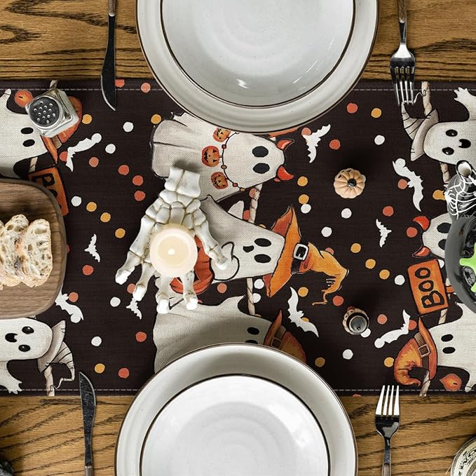 Close-up of Halloween table runner fabric with cartoon ghosts, bats, and pumpkins
