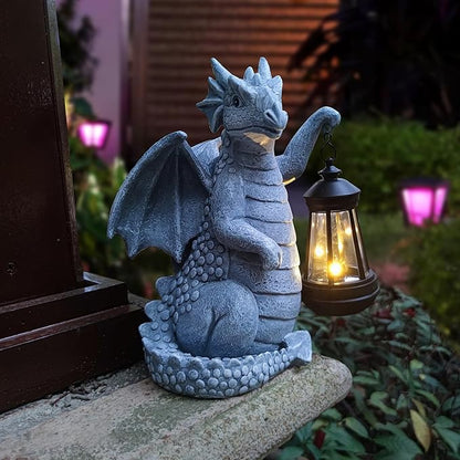 Blue dragon garden statue with open wings and glowing lantern at night