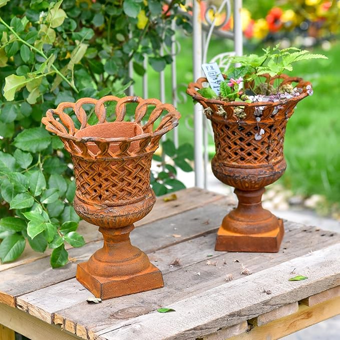 Pair of openwork cast-iron urn planters with crisscross lattice and pedestal stands
