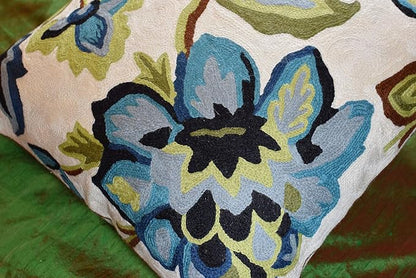 Corner view floral pillow cover with blue flower clusters on cream textured needlepoint