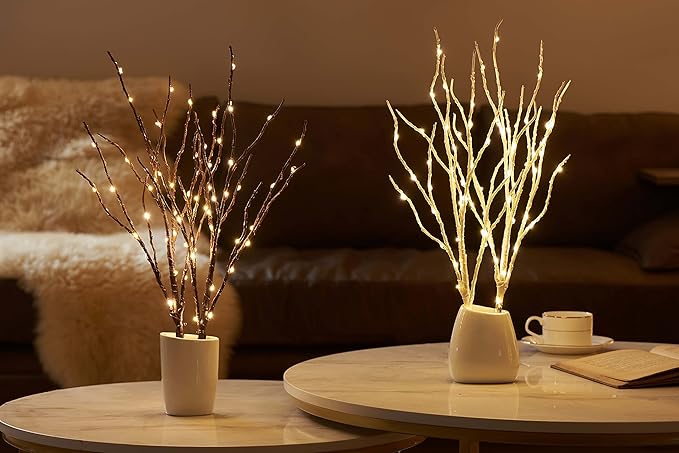 Two brown lighted willow branches in pots with warm white LED glow on table
