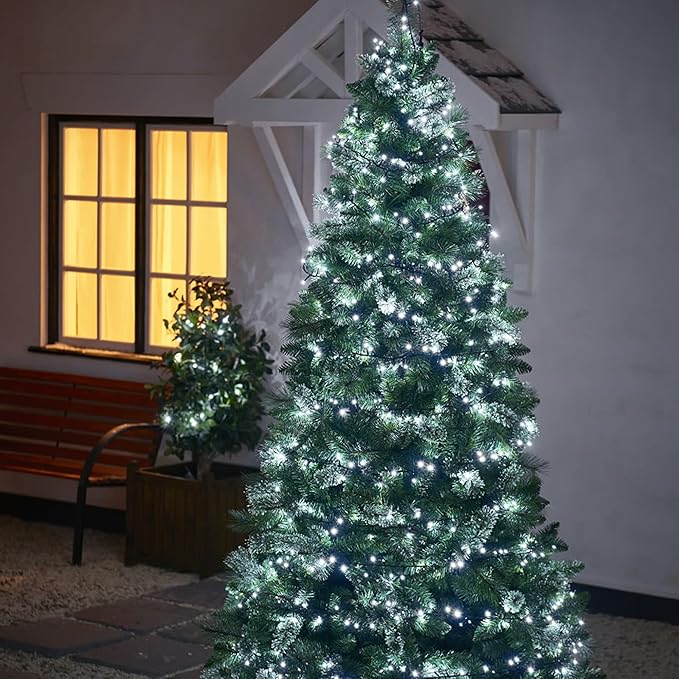 Outdoor Christmas LED string lights on tree with cool white bulbs on green wire