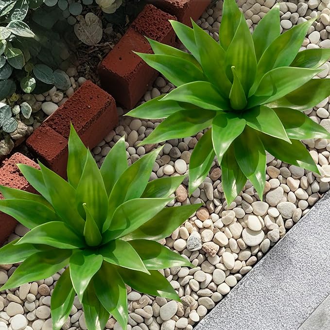 Two green faux agave plants with spiky leaves in terracotta-colored pots