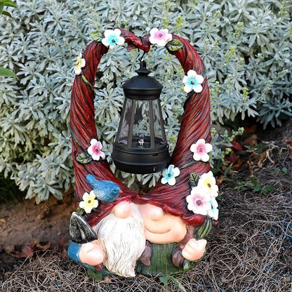 Resin gnome couple with glowing lantern under floral vine ring, outdoor yard decor