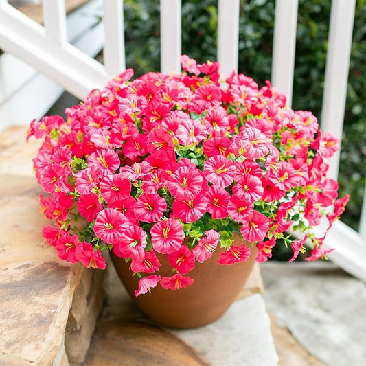Hot pink faux morning glory bouquet with green leaves, arranged in terracotta pot