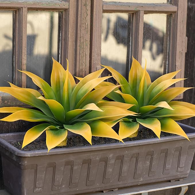 Yellow-green faux agave plants in rectangular planter with faux trunk stems