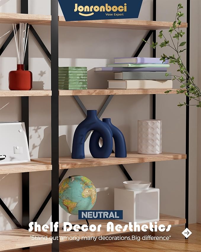 Matte navy ceramic hug sculpture vase with donut cutout, on shelf.