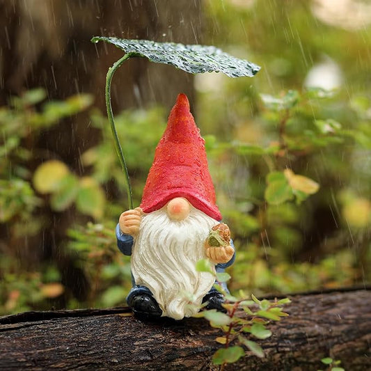 Garden gnome statue with red hat, white beard, blue pants and leaf umbrella