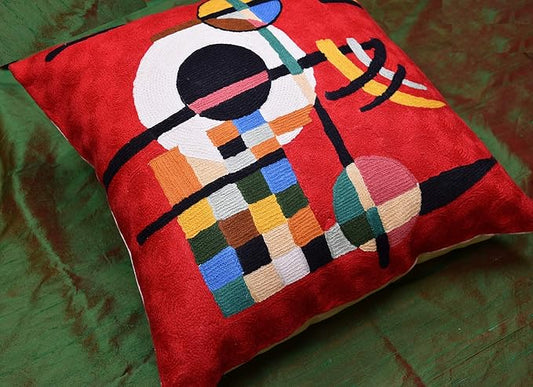 Red abstract embroidered wool pillow cover, diagonal view of multicolor geometric pattern