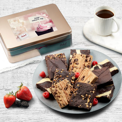 Assorted brownie gift tin with sliced chocolate brownies on a plate and strawberries