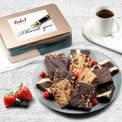 Assorted brownie gift tin with sliced chocolate brownies on a plate and strawberries