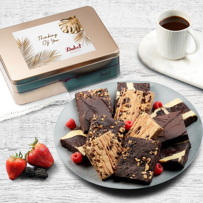 Assorted brownie gift tin with sliced chocolate brownies on a plate and strawberries
