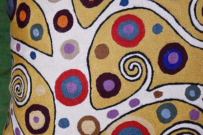 Decorative pillow cover close-up with colorful circular designs and swirl embroidery
