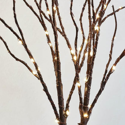 Close-up of brown willow branches wrapped with warm white LED fairy lights
