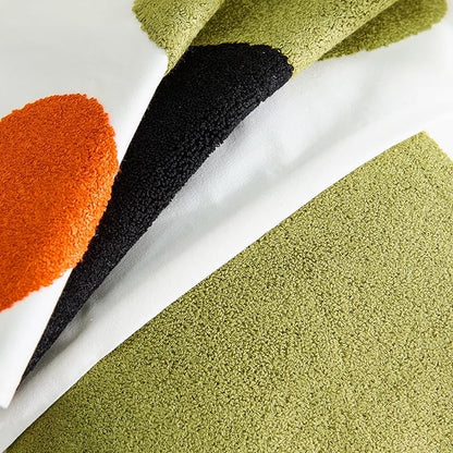 Close-up of tufted pillow cover fabric showing olive-green, black, and orange circle patches