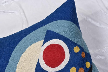 Close-up of blue abstract pillow cover with cream arch and red circle detail