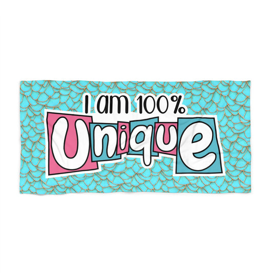 Turquoise beach towel with mermaid-scale pattern and bold 'I am 100% Unique' text