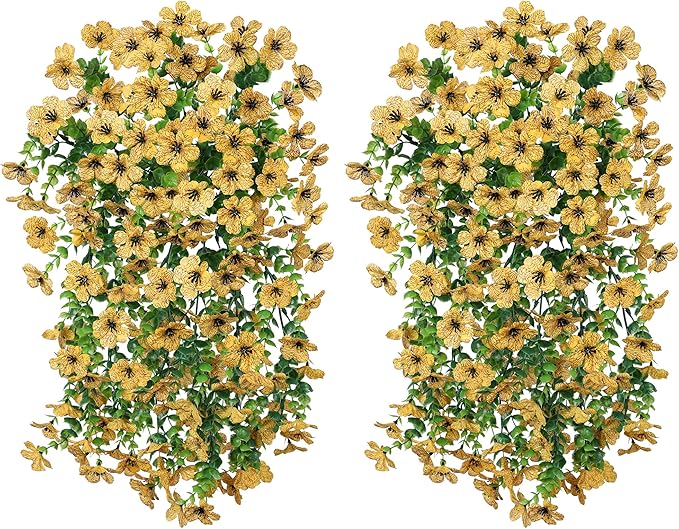 Two yellow faux daisy hanging bundles with trailing green eucalyptus-style leaves