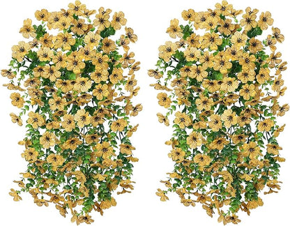 Two yellow faux daisy hanging bundles with trailing green eucalyptus-style leaves