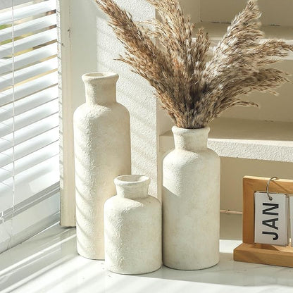 Three whitewashed ceramic vases with textured finish, varying heights on display