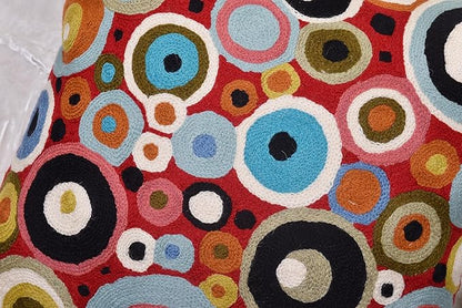 Red pillow cover front filled with multicolor rings and circles, textured embroidery