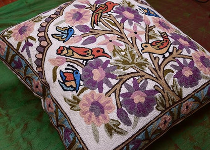 Needlepoint pillow cover with colorful birds perched among purple blossoms