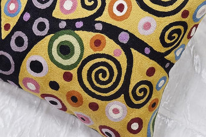 Close-up pillow cover corner with embroidered circular swirl pattern in yellow and black