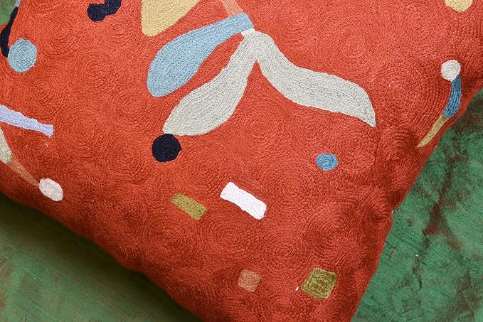 Orange abstract pillow cover with large beige flower shapes and blue dot details