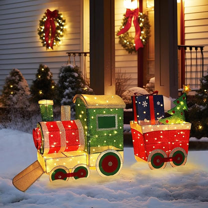 Light-up Christmas train decor set with green engine, red cars, and warm-white lights on snow