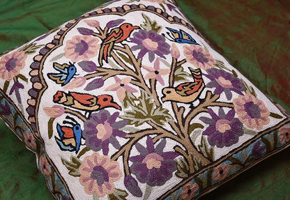 Corner view of embroidered tree-and-birds pillow cover with purple floral accents