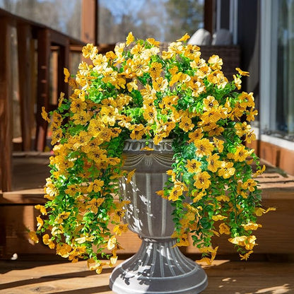 Yellow faux daisy hanging flower bundle in gray pot with trailing green leaves