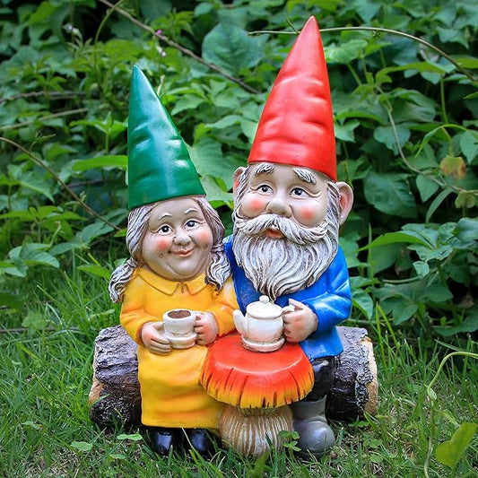 Garden gnome couple figurines, blue and orange, holding white mugs on a log base