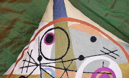 Top corner of wool pillow cover showing cream, purple ring circle, and black line web.
