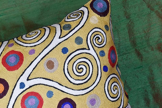 Decorative pillow cover detail: yellow fabric with colorful circular swirl embroidery