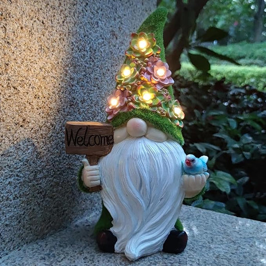 White resin garden gnome holding a “Welcome” sign and a blue bird with glowing lights