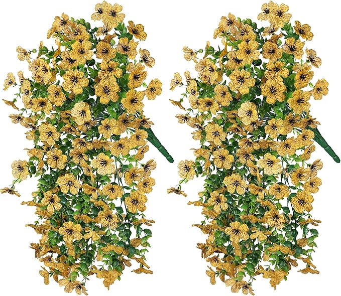 Two yellow faux daisy hanging bundles with trailing green eucalyptus-style leaves