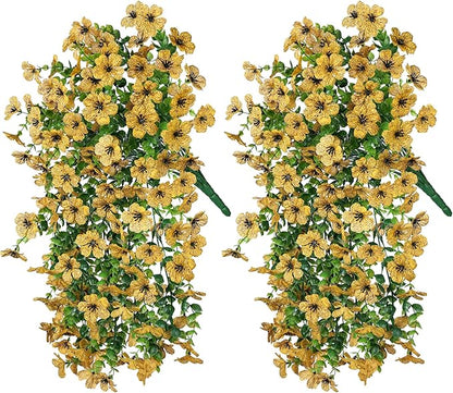 Two yellow faux daisy hanging bundles with trailing green eucalyptus-style leaves