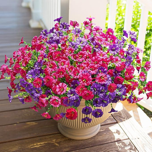 Faux morning glory flower bundles with purple and fuchsia blooms in a white pot.