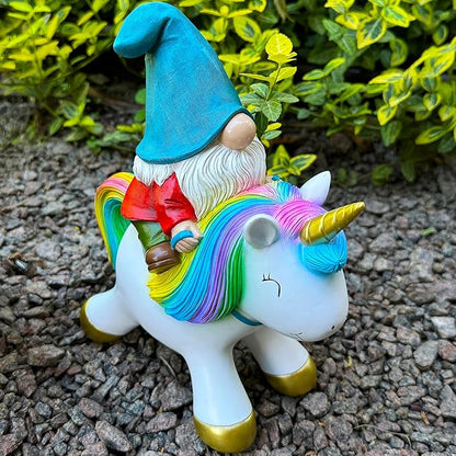 Close side view of unicorn figurine with rainbow mane, horn, and gnome in blue hat