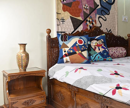 Blue abstract geometric pillow cover with colorful lines, triangles, and red circle