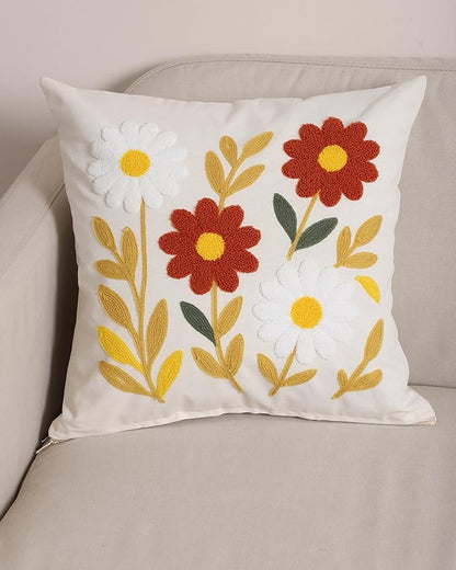 White floral cushion cover with punch-needle daisies and leaves on a sofa