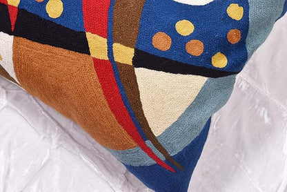 Close-up of blue abstract pillow cover with brown panel, red stripe, and yellow circles