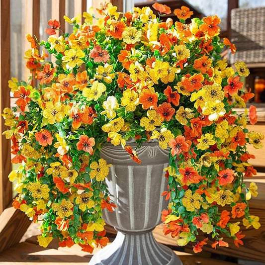 Artificial hanging flower bundles with orange and yellow blossoms and trailing green leaves
