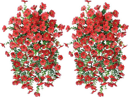 Two red faux hanging flower bundles with green leaves and trailing red blossoms